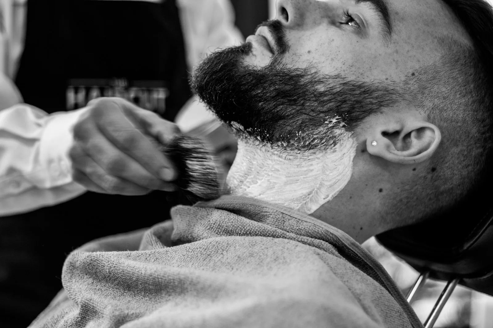 Professionnel en train de tailler barbe et cheveux dans un salon